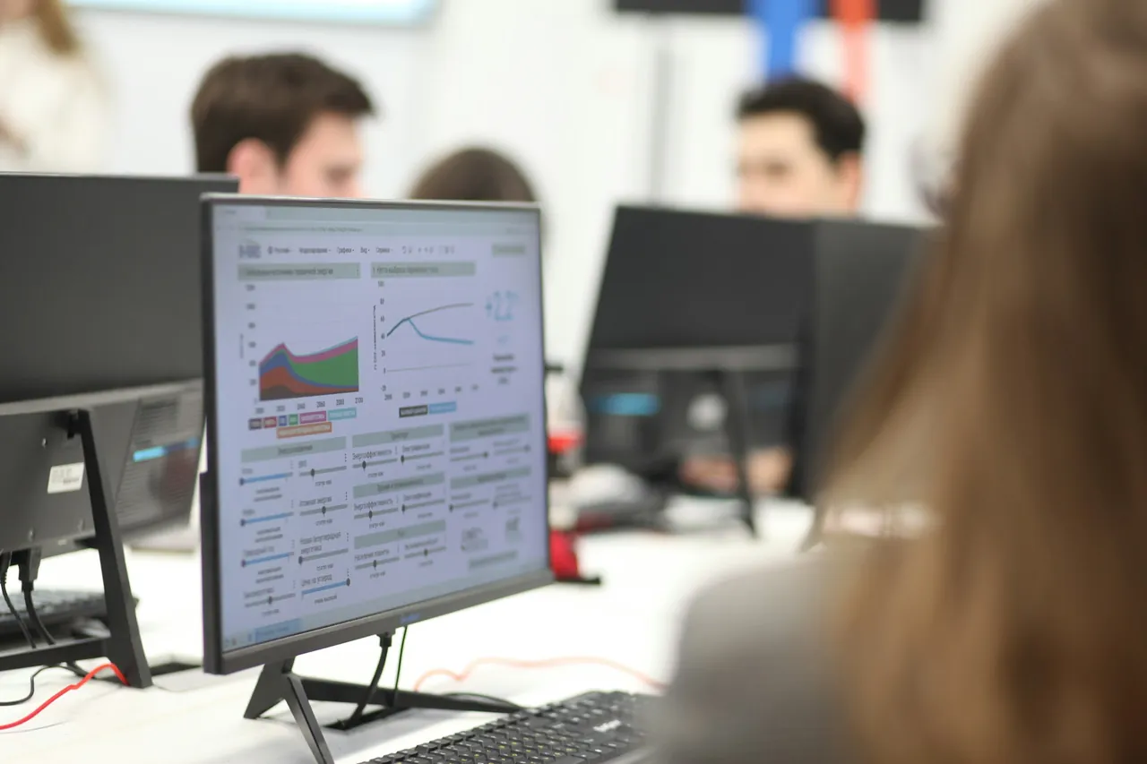 An office team at their computers, one screen showing a data dashboard
