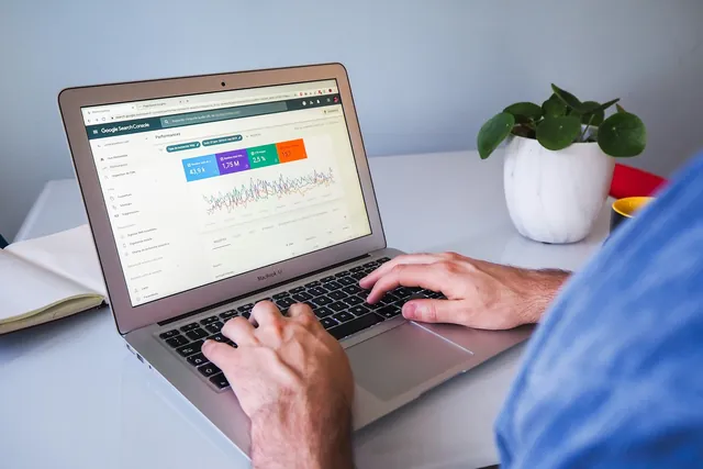 A laptop showing a search performance chart on a white desk